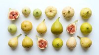 Fresh figs and pears arranged on white background, whole and halved fruits showing interior texture and seeds, suitable for food photography, culinary design, healthy eating content, and organic produce marketing.