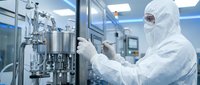 Scientist in protective suit working with pharmaceutical manufacturing equipment in sterile laboratory environment for drug production and quality control.