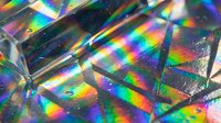 Holographic prism surface with vibrant rainbow light refraction creating colorful spectrum patterns, suitable for backgrounds, design elements, and abstract visual projects.