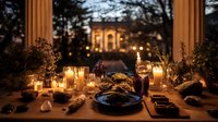 Elegant dinner table with candles and wine at dusk, overlooking illuminated mansion through columns. Romantic outdoor dining atmosphere.