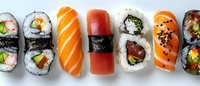 Fresh assorted sushi rolls and nigiri with salmon, tuna, and vegetables arranged in row on white background. Traditional Japanese cuisine close-up view.