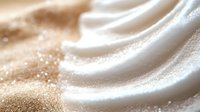 Luxurious cream silk fabric with golden shimmer particles flowing in elegant waves creating sophisticated textile background for fashion and beauty projects.
