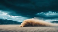 Dramatic dust storm rolling across desert plain with dark turquoise storm clouds overhead, creating powerful contrast between earth and sky in mountainous landscape.