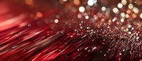 Red fiber optic strands with glowing bokeh lights creating dynamic motion effect against dark background, modern technology concept for digital communications.