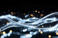 Abstract flowing waves of glowing particles and bokeh lights on dark background create magical atmosphere for festive designs and holiday projects.