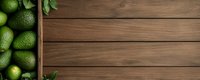 Fresh green avocados in wooden box on rustic dark wooden table background with copy space, top view. Food photography layout for menu design.