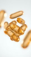 Golden omega-3 fish oil capsules scattered on white background for health and wellness supplement marketing materials.