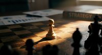 Chess pawn piece standing alone on wooden board with dramatic lighting and shadows creating strategic game atmosphere for business concepts.