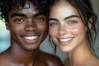 Close up portrait of young diverse couple with bright genuine smiles, perfect white teeth, and striking eyes looking at camera. Natural beauty and authentic joy.