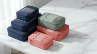 Colorful travel packing cubes set organized on marble surface for luggage organization and efficient suitcase storage solutions.