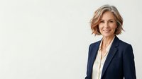 Middle-aged woman with shoulder-length blonde hair, wearing navy blazer over white blouse, smiling at camera against white background for corporate and business use.