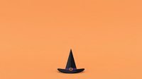 Isolated black witch hat with buckle detail on warm orange background, ready for design projects, apparel printing, and seasonal marketing materials.