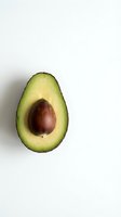 Fresh avocado half with pit on white background isolated for healthy eating and cooking designs.