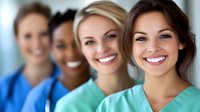 Diverse group of female healthcare professionals smiling in medical scrubs standing together in hospital or clinic setting for teamwork concept.
