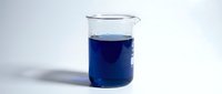 Deep blue liquid in laboratory glass beaker on white background, suitable for chemistry, science education, medical research, and scientific experimentation visuals.