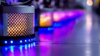 Atmospheric metal mesh candle holder with glowing flame against vibrant purple and blue bokeh background creates moody ambient lighting effect for romantic settings.