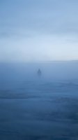 Solitary figure standing in dense fog on vast frozen landscape, creating atmospheric mood for isolation, loneliness, and contemplation themes in editorial and creative projects.