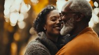 Mature African American couple embracing outdoors with warm autumn bokeh background, conveying love, connection and happiness in later years.
