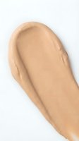Liquid foundation makeup smear swatch on white background showing medium beige tone coverage for cosmetic beauty product testing and color matching.