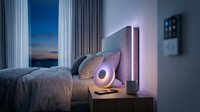 Cozy modern bedroom at night with smart lighting, glowing bedside lamp, and ambient LED strips creating a relaxing atmosphere.