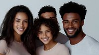 Happy diverse family portrait with smiling parents and children showing love and togetherness on neutral background for lifestyle campaigns.