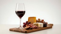 Elegant wine and cheese board with red wine glass, artisan cheeses, grapes, nuts and crackers on wooden serving platter for gourmet dining and entertaining.