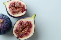 Fresh ripe purple figs cut in half showing juicy red flesh and seeds on white background, overhead view. Perfect for healthy eating, food blogs and Mediterranean cuisine content.
