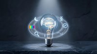 Light bulb with glowing brain inside surrounded by creative icons on dark textured background representing innovation and intelligent thinking concepts.