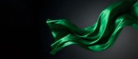 Flowing green silk fabric with elegant curves and waves against dark background for luxury fashion and textile design projects.