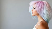 Young woman with pastel rainbow hair in profile view against gray background. Modern hairstyling and beauty concept for salon advertising and fashion content.