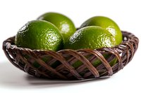 Fresh green limes in rustic woven basket on white background, bright citrus fruits with textured peel, food photography for healthy cooking and cocktails.