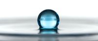 Transparent blue glass sphere resting on reflective wet surface with ripples, isolated on white background for design and commercial use.