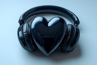 Black heart-shaped object with headphones on light blue background, representing music love and audio passion for design projects.