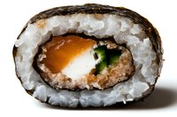 Close-up macro shot of fresh sushi roll slice showing layers of rice, nori, salmon, cream cheese and cucumber against white background. Authentic Japanese cuisine.