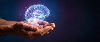 Human hands holding glowing digital brain with neural network connections on dark background for artificial intelligence and technology concepts.