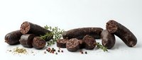 Artisan chocolate sausages with herbs and spices on white background. Gourmet confectionery products for culinary photography and food design projects.