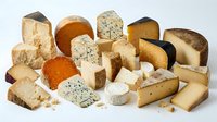 Assorted gourmet cheese collection featuring aged cheddar, blue cheese, brie, gouda and artisanal varieties isolated on white background for culinary design.