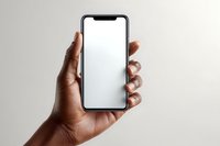 African American male hand holding modern smartphone with blank white screen mockup against neutral beige background for app presentation and design.