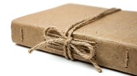 Kraft paper box tied with natural twine bow, isolated on white background, suitable for packaging, shipping, gift wrapping, and e-commerce product presentation.