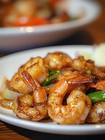 Grilled shrimp with glazed sauce on white plate, close up view of succulent seafood with green vegetables and caramelized coating, selective focus on juicy prawns.