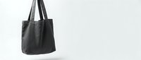 Black leather tote bag hanging against white background, minimalist fashion accessory for shopping and everyday use, isolated design element.