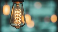 Vintage Edison bulb with spiral filament glowing warmly against soft bokeh background creating cozy atmospheric lighting for interior design and decor projects.