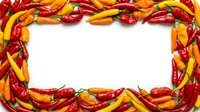 Colorful hot peppers arranged in rectangular frame border with red, yellow, and orange varieties on white background. Food styling for culinary content.