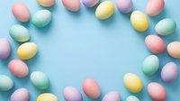 Pastel colored Easter eggs arranged in a circular frame on a light blue background with copy space for text.