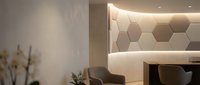 Modern hotel lobby reception area with hexagonal wall panels and warm ambient lighting, contemporary interior design for hospitality and commercial spaces.