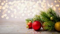 Christmas decoration with red and gold ornaments, pine branches on wooden surface against blurred bokeh lights background. Perfect for holiday designs.