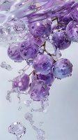 Fresh purple grapes submerged in crystal clear water with dynamic splashes and droplets creating an elegant, refreshing composition against light background.