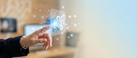 Hand touching glowing digital network connections with sparkles in modern office environment for technology and innovation concepts.