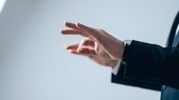 Professional businessman hand gesture showing presentation or explanation in modern office setting for business communication and corporate meetings.