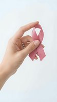 Female hand holding pink awareness ribbon symbol for breast cancer support and healthcare advocacy on white background.